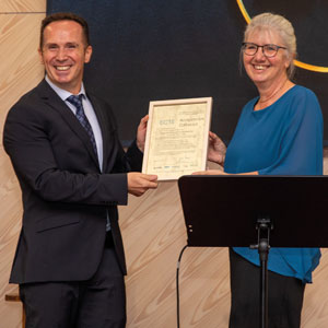 Hervin Fushekati accepts the ECTE certificate from Carmen Crouse