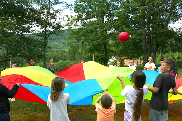 Children playing a parachute and ball game
