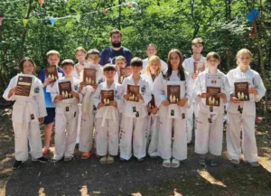 Taekwondo students with their study books and certificates